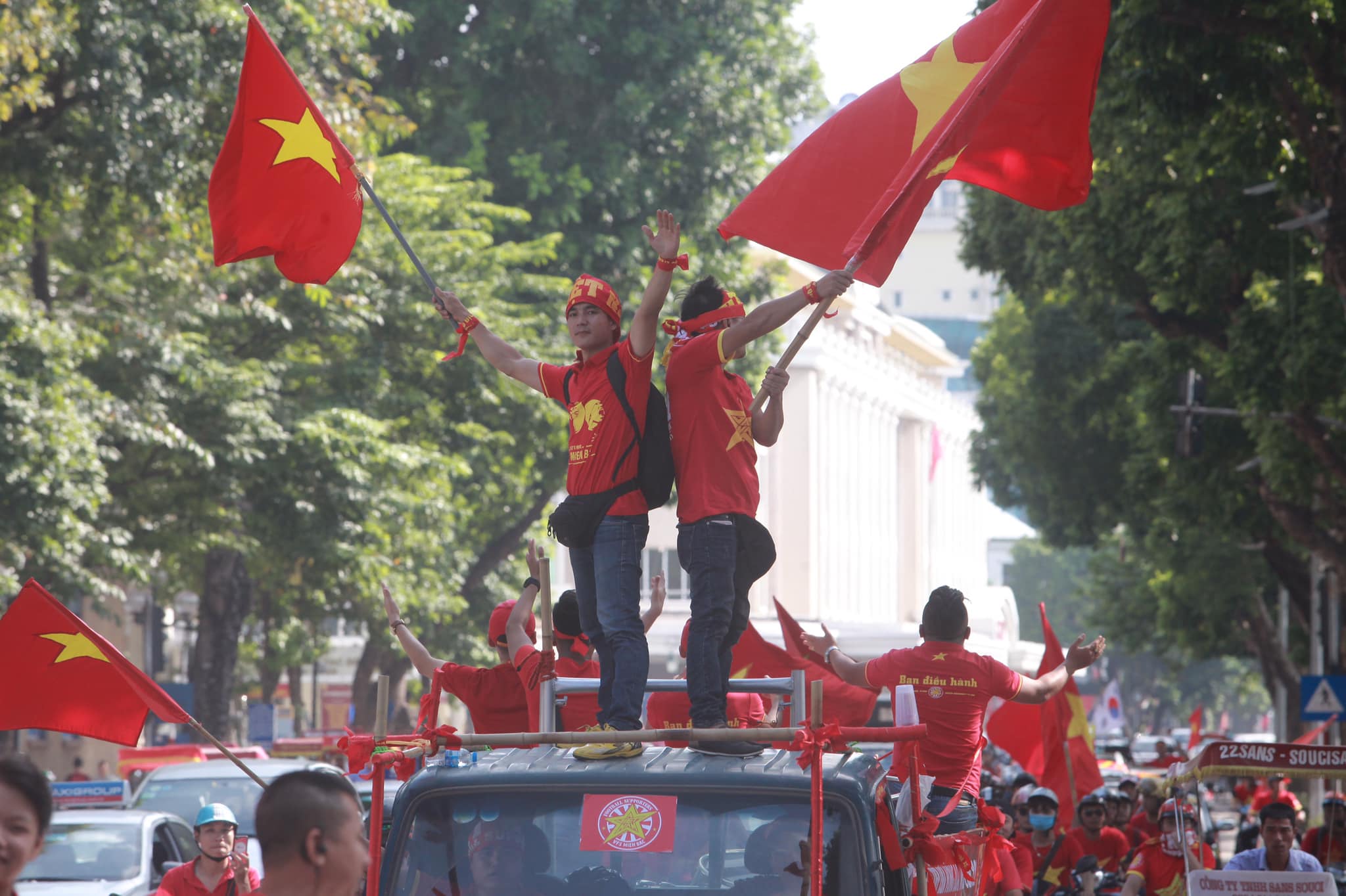 Thành viên trong đoàn đứng lên nóc buồng lái vẫy cờ cổ vũ.