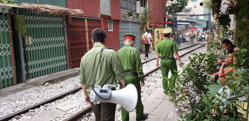 Cảnh sát dùng loa đi nhắc nhở các hộ dân ven đường không được vi phạm hành lang ATGT đường sắt