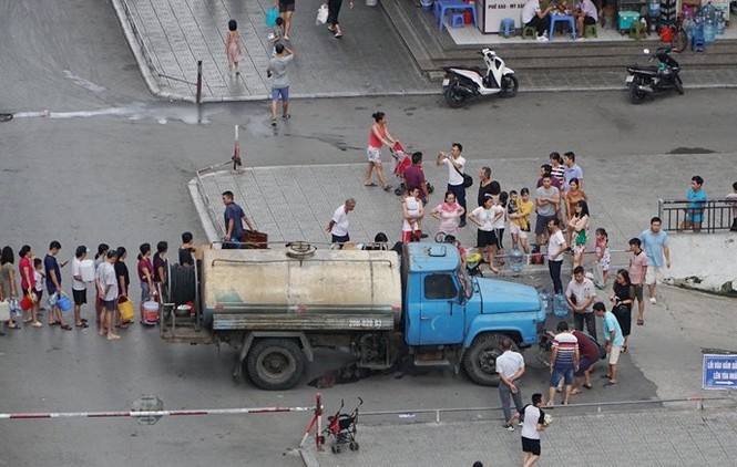 Chiều qua, người dân KĐT HH Linh Đàm xếp hàng chờ lấy nước từ xe téc kéo dài cả trăm mét