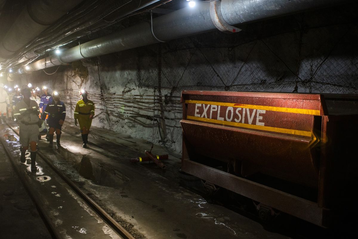 Công nhân đi qua một thùng vật liệu nổ bên trong trục mỏ tại mỏ bạch kim Sibanye, Khuseleka. (Nguồn: Bloomberg)