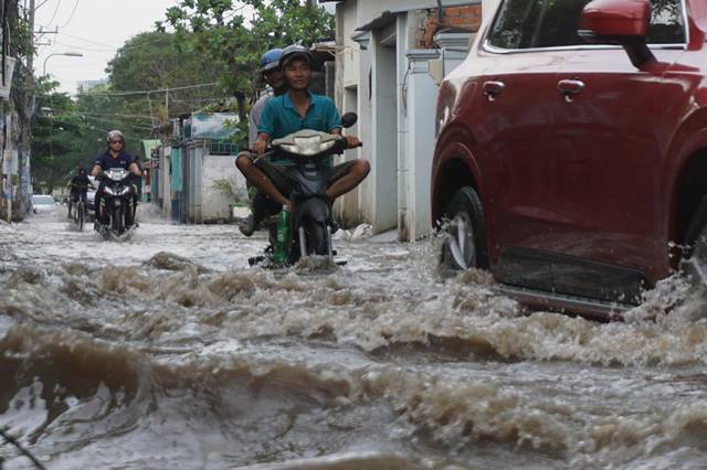 Mỗi khi có xe ô tô chạy qua tạo thành sóng nước văng tung tóe hai bên đường.