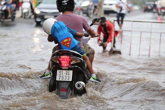 &nbsp; Phụ huynh đón con đi học trở về nhà phải “bơi” trong nước ngập