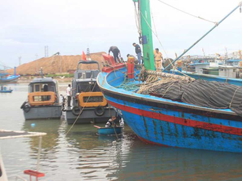 Các lực lượng chức năng đang cứu hộ một tàu cá ở vịnh Quy Nhơn. Ảnh: HT