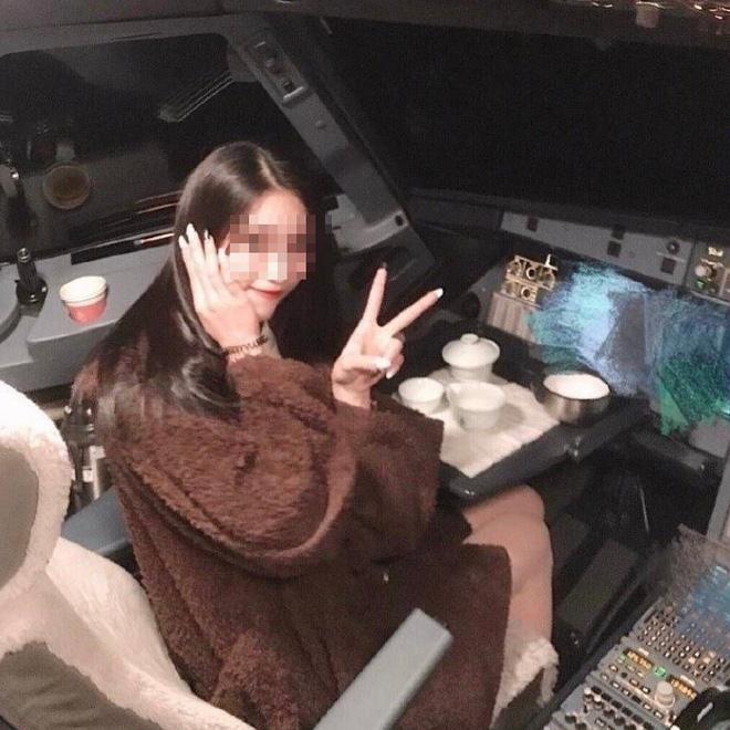 Nữ sinh tạo dáng trên ghế của phi công, cạnh bộ ấm trà