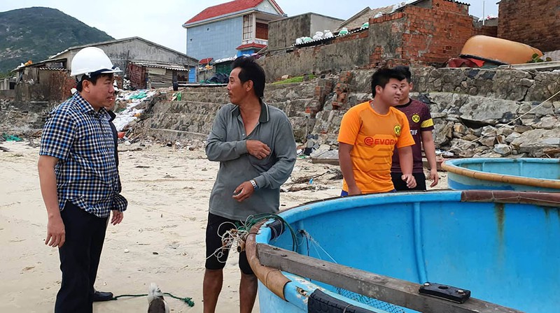 Ông Trần Hữu Thế, Phó Chủ tịch UBND tỉnh Phú Yên (bìa trái) trao đổi với người dân xã Xuân Hòa, thị xã Sông Cầu đang đưa đồ đạc đi tránh bão. Ảnh: TẤN LỘC