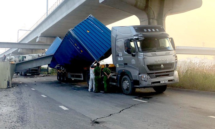 Một phần công trình với các khối bê-tông ngổn ngang bị kéo đổ, đè bẹp thùng container