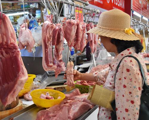 Người tiêu dùng chọn mua thịt heo tại chợ Bến Thành, TP HCM. Ảnh: TẤN THẠNH