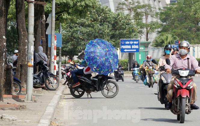 Thậm chí, nhiều người dựng xe dưới lòng đường, che ô chống nắng chờ khách.