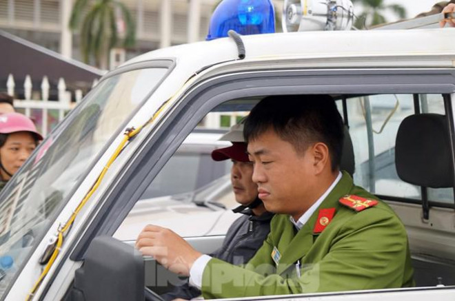 Cảnh sát mời người này lên xe chuyên dụng về trụ sở công an.