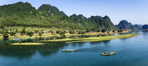 Thuyền chạy trên Sông Son, chở khách thăm quan hang động Phong Nha.
