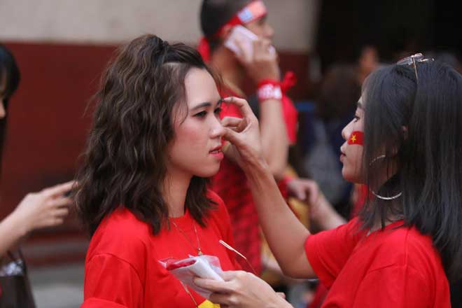 Các CĐV nữ Việt Nam dán những lá cờ Việt nam lên mặt trước khi trận đấu diễn ra