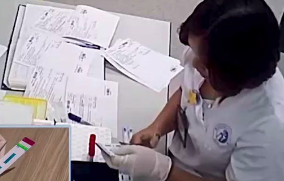 Kỹ thuật viên cắt đôi que thử&nbsp;HIV, viêm gan B tại BV Xanh Pôn.
