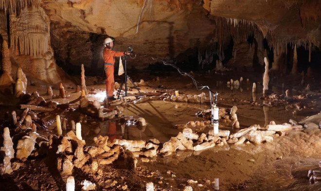 Một người đang thực hiện phép đo vòng đá bên trong hang động Bruniquel ở Pháp, nơi có thể từng là chỗ ở của người Neanderthal.