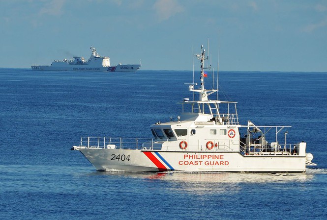 Tàu cảnh sát biển Philippines (phải) đang diễn tập tìm kiếm, cứu nạn với tàu cảnh sát biển Mỹ gần bãi cạn Scarborogh ở biển Đông, trong khi tàu hải cảnh Trung Quốc (trái) đang dòm ngó (ảnh chụp ngày 14/5/2019)Ảnh: Getty