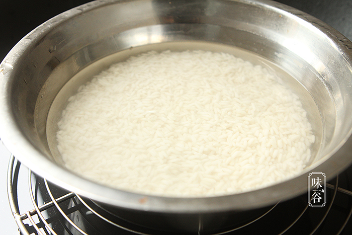 Ngâm gạo nếp trước 30 phút, sau đó cho một lượng nước thích hợp rồi nấu trong nồi cơm điện hoặc chõ xôi.