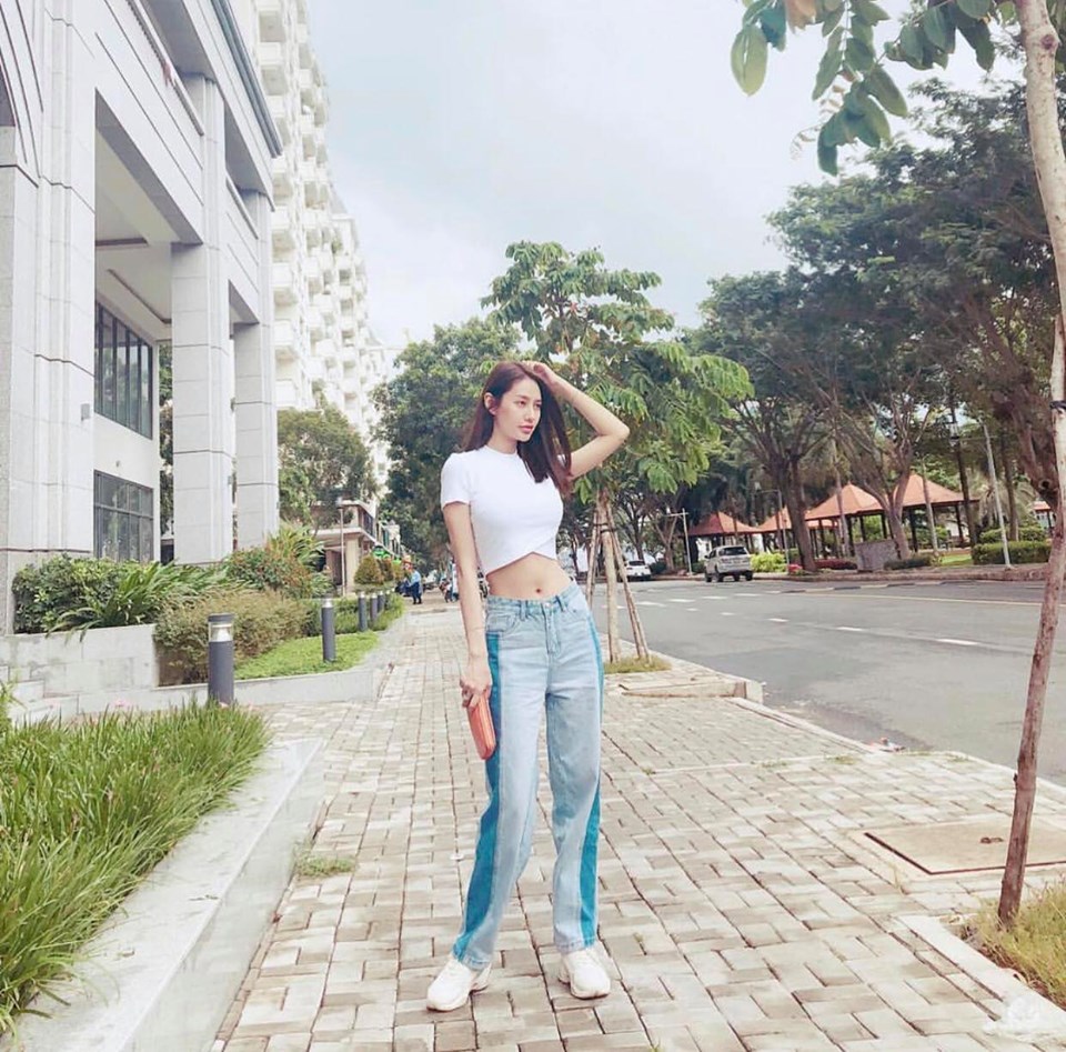 Công thức lên đồ của Linh Chi đơn giản với 2 tông màu trên một outfit, năng động với jean cạp trễ và đôi giày thể thao tông trắng kinh điển. Nhan sắc xinh đẹp của cô đủ thu hút mọi ánh nhìn mà chẳng cần phải lên đồ cầu kỳ.