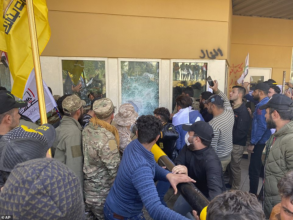 Đám đông biểu tình, trong đó có cả một số người mặc quân phục, tấn công dữ dội vào đại sứ quán Mỹ, tại thủ đô của Iraq (ảnh: Dailymail)