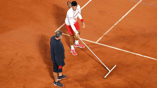 Djokovic giúp nhân viên sân Philippe-Chatrier lau nước mưa đọng trên sân