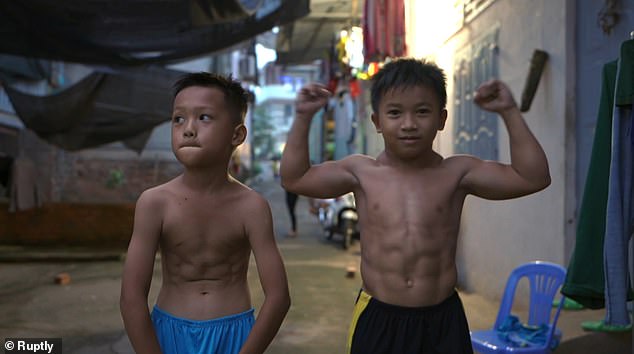 Nguyen Hoang Nam (phải) đọ cơ bắp với bạn cùng trang lứa. Ảnh: Ruptly&nbsp;