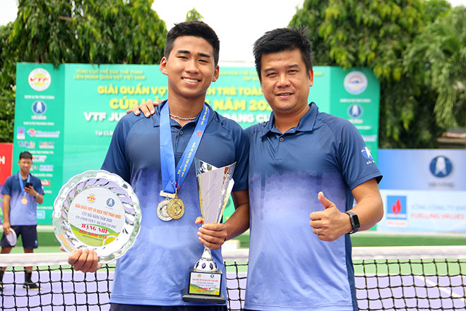 Minh Đức ăn mừng chức vô địch U18 đơn nam bên cạnh người phụ trách Nguyễn Phi Anh Vũ