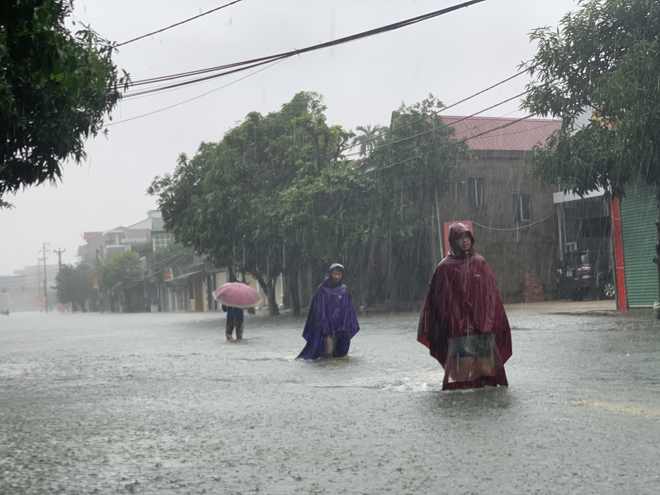 Các phương tiện không thể di chuyển trên tuyến đường này. Người dân phải&nbsp;đi bộ vượt lũ&nbsp;đến chợ để mua nhu yếu phẩm về sử dụng.