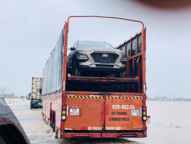 Nước ngập sâu, xe nối đuôi nhau di chuyển chậm qua tuyến đường này.