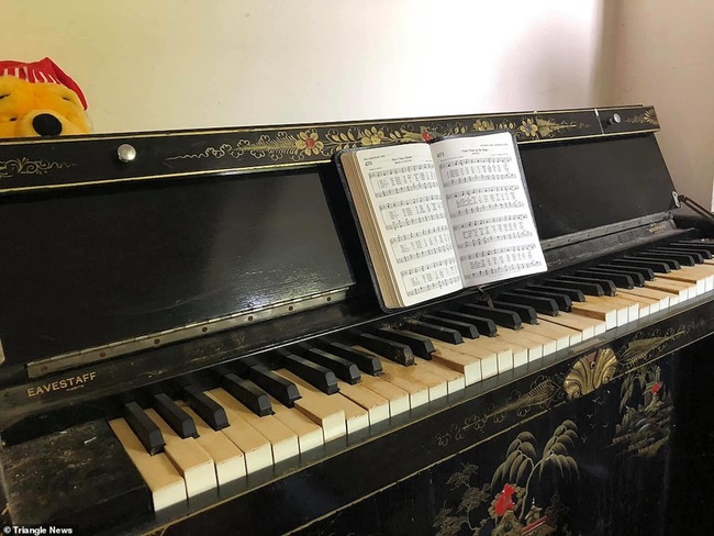 Bên trong nhà còn có cây đàn piano, ghế sofa, các đồ sứ đặt trên bàn ở phòng khách.
