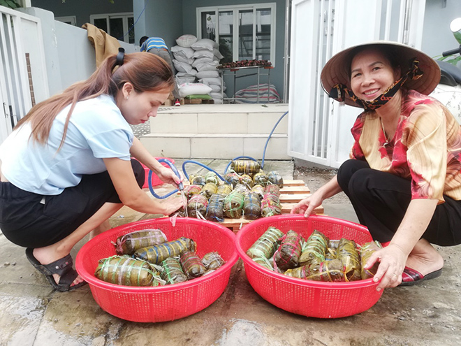 &nbsp;“Tôi quê ở Nghệ An và đã từng biết được cảnh lũ lụt ở miền Trung là như thế nào. Những ngày qua, khi nghe thông tin về trận lũ lịch sử diễn ra tại các tỉnh miền Trung gây thiệt hại nặng nề về tính mạng và tài sản, nhiều đồng bào mắc kẹt trong lũ thiếu thức ăn nước uống, tôi rất xót xa. Vì vậy, tôi cùng gia đình gói bánh chưng, bánh tét để gửi cho đồng bào miền Trung. Tôi rất cảm động vì rất nhiều người dân đồng hành cùng tôi góp chút sức lực, lòng thành để hỗ trợ bà con vùng lũ”, bà Loan chia sẻ. Trong ảnh: Bánh sau khi được nấu chín được rửa lại bằng nước sạch.