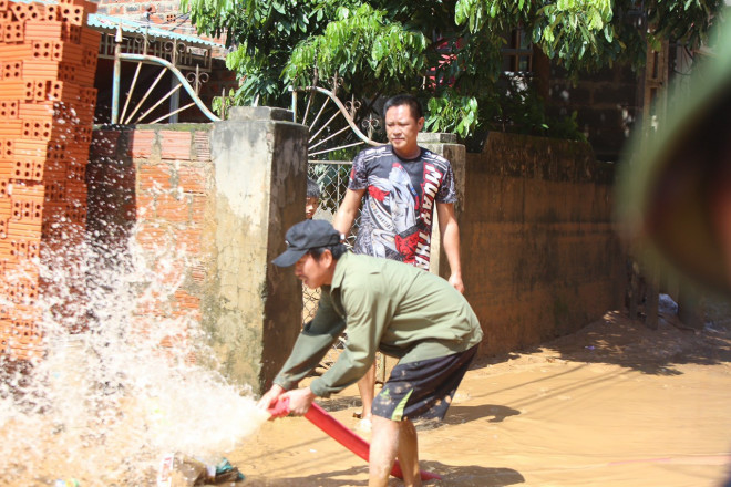 Bùn ngập tràn vào nhà quá nhiều và đọng lại, sau cào đổ, người dân Quảng Ninh dùng nước vệ sinh tránh dịch bệnh.