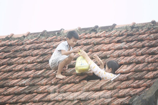 Trong đêm, lũ ngập vào trong nhà và dâng lên nhanh chóng, chẳng kịp "cứu" tài sản, người dân Lệ Thủy (Quảng Bình) cuống cuồng lên nóc nhà tránh nạn. Cánh cửa từ mái ngói mở ra, người dân nhìn biển nước trong nỗi buồn vô hạn. Đây cũng là cánh cửa "bất đắc dĩ" mà những ngày qua, người dân nơi đây ra, vào đón nhận cứu trợ.