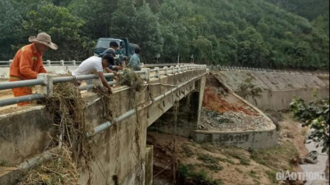 Nước lũ tràn qua cả bề mặt, thành cầu đọng lại rác thải