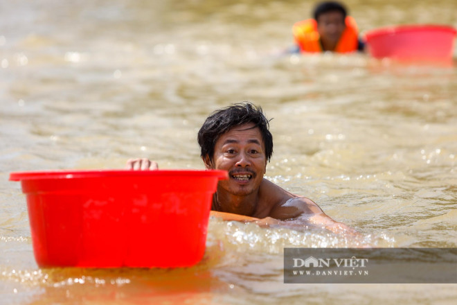 Người dân vui sướng hân hoan, bơi thật nhanh về phía đoàn cứu trợ, mang theo chiếc chậu to để nhận đồ tiếp tế.