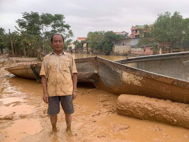 Ông Bình cùng chiếc đò bị vỡ. Ảnh: Minh Quê