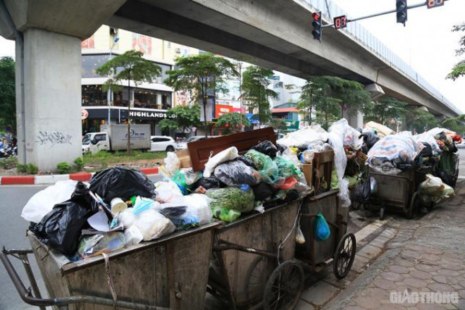 Cách đó không xa, trên đường Hoàng Cầu, người tham gia giao thông cũng cảm thấy khó chịu khi đi qua những xe rác xếp dài dưới lòng đường.