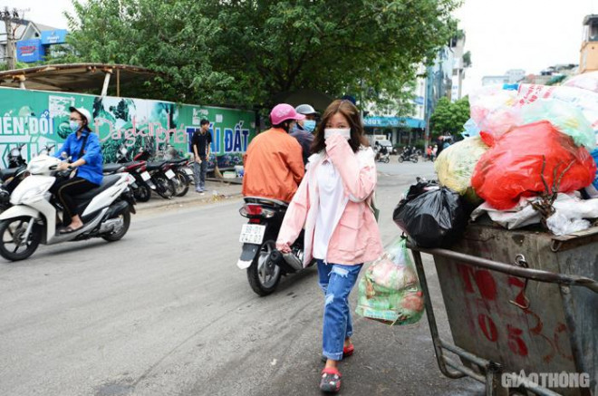 Người dân bịt mũi mỗi khi phải đi qua dãy xe rác kéo dài hàng chục mét.