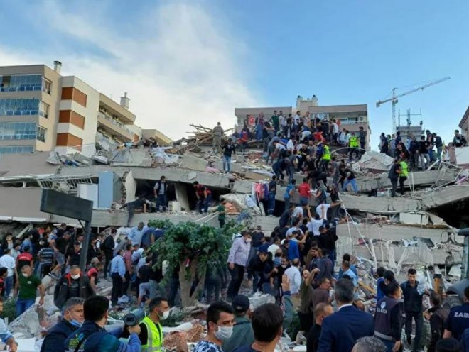Người dân và đội cứu hộ đang tìm kiếm người bị mắc kẹt trong một tòa nhà bị sập ở Thổ Nhĩ Kỳ. Ảnh: REUTERS