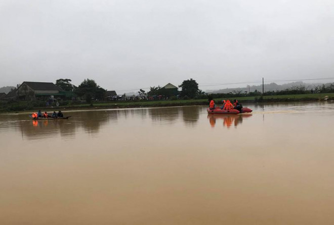 Lực lượng chức năng tìm kiếm hai anh em anh Quảng, anh Thế trên cánh đồng nước lũ.&nbsp;