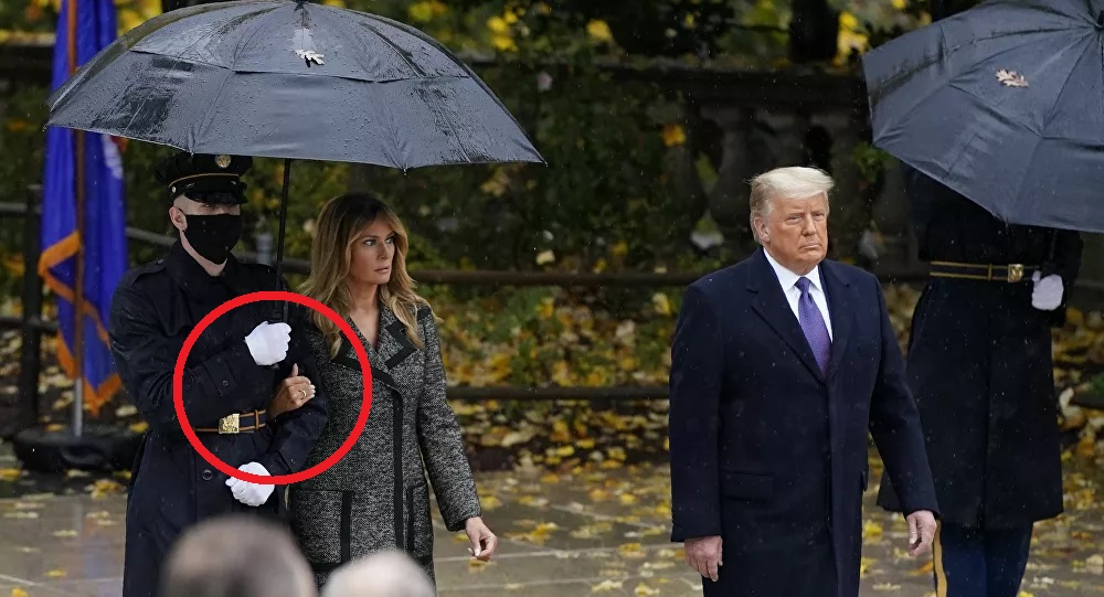 Bà Melania khoác tay binh sĩ đi cùng khiến dư luận xôn xao. Ảnh: AP