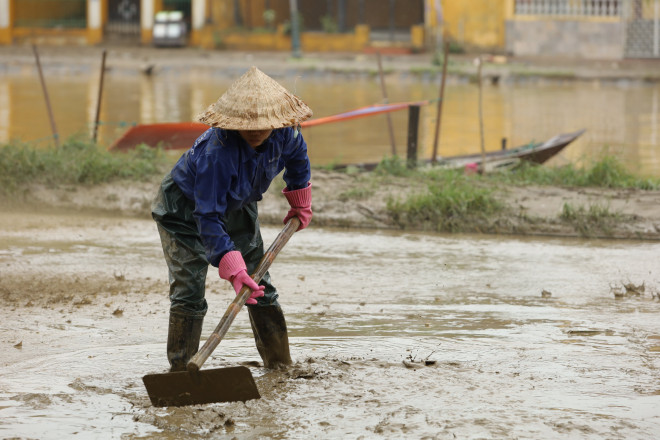 Khối lượng bùn non rất dày tràn vào tuyến đường ven sông Hoài.