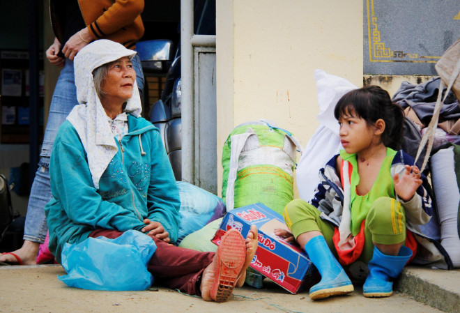 Bà Hồ Thị Do cùng cháu gái nghỉ ngơi sau hơn 3 giờ đi bộ xuyên rừng để nhận nhu yếu phẩm