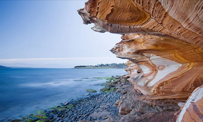 Vách đá Painted (Tasmania): Nước ngầm thấm qua lớp sa thạch hàng triệu năm trước để lại dấu vết của các ôxít sắt, do đó tạo ra một dải hoa văn tuyệt đẹp kéo dài 100m trông giống như tác phẩm sơn.&nbsp;
