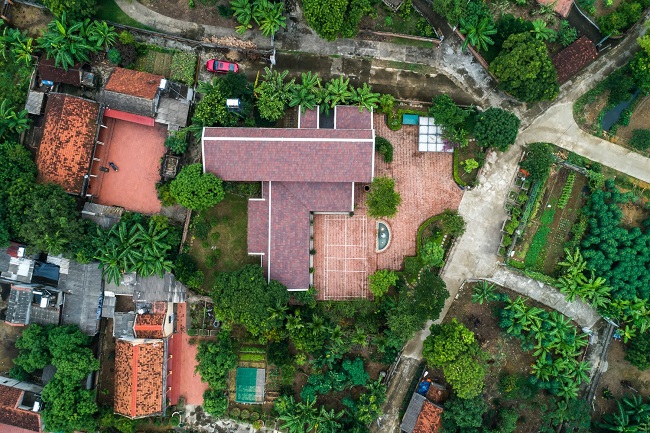 Toàn cảnh X – House nhìn từ trên cao xuống với những đường nét đậm chất làng quê Việt: gạch đỏ, mái ngói và những hàng cây xanh mát quanh nhà.
