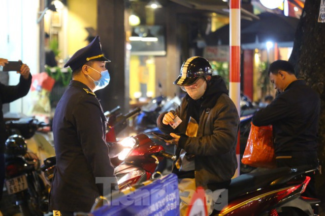 Một người dân đưa chứng minh thư ra làm "bằng chứng" để được đi xe về nhà nằm trong khu vực phố đi bộ. Ảnh: Duy Phạm