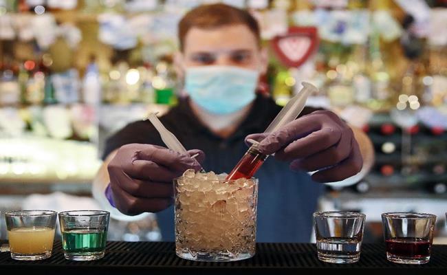 Một quán bar tại Nga đã sáng chế ra một loại cocktail đặc biệt mang tên… virus Corona. Loại nước uống này được phục vụ với 2 ống tiêm y tế, 1 ống màu xanh lá cây tượng trưng cho virus Sars-CoV-2 còn ống màu đỏ tượng trưng cho thuốc giải.
