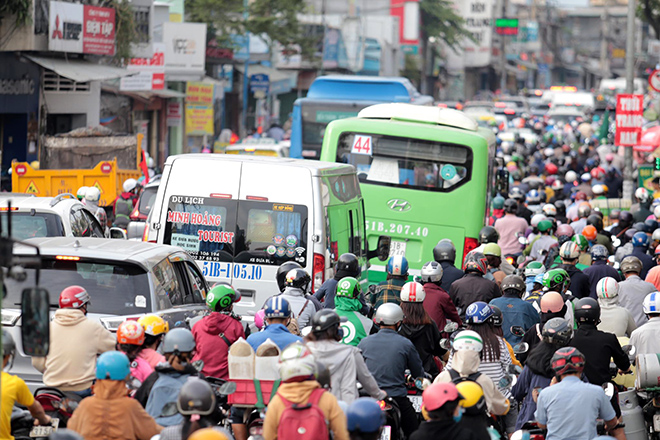 “Biển người” xếp hàng hướng ra bến xe Miền Đông. Trên đường ra bến xe Miền Đông, lo sợ trễ chuyến, rất nhiều người mang ba lô, hành lý và quà đã xuống khỏi xe buýt, xe taxi và “cuốc bộ” đến bến xe.