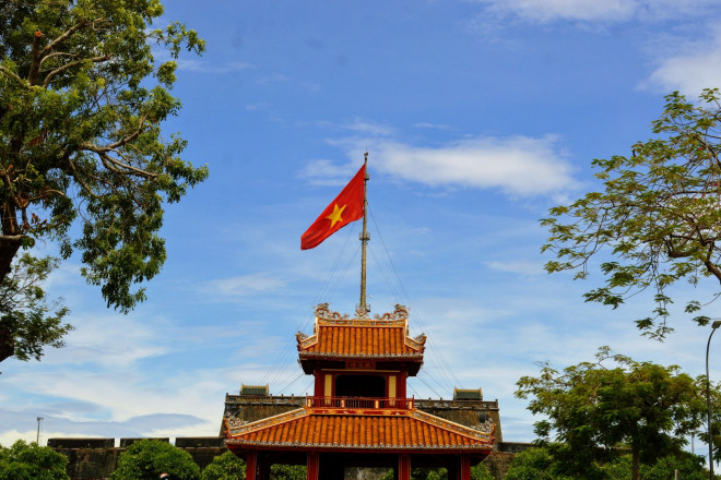 Phu Văn Lâu và phía sau là lá cờ tung bay ở Kỳ Đài Huế.