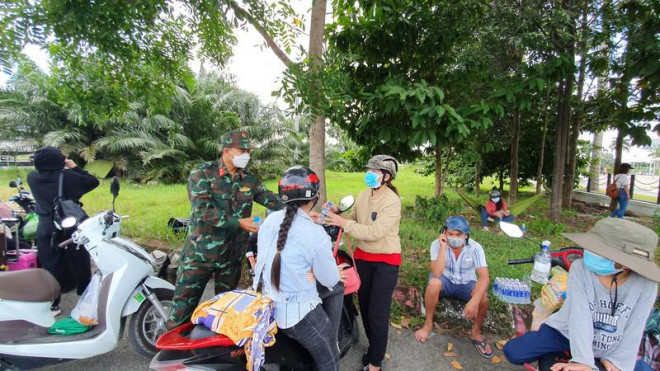 Lực lượng chức năng hỗ trợ nước uống cho các công dân. Ảnh: CHÂU ANH