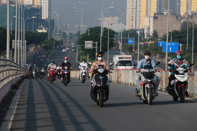 Người dân TP.HCM ra đường tham gia các hoạt động kinh doanh, sản xuất sáng 1-10; Ảnh: Hoàng Triều