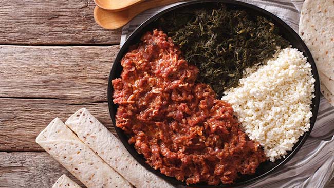 15. Kitfo

Kitfo là một món ăn phổ biến ở Ethiopia, bao gồm thịt bò tươi xay nhuyễn kết hợp với bơ Ethiopia và các loại gia vị như ớt, muối. Món ăn này được phục vụ với nhiều loại bánh mì khác nhau, pho mát mặn và rau xanh.
