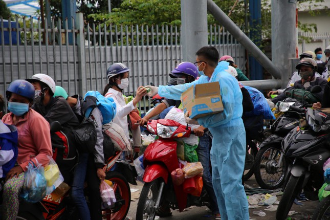 Lực lượng chức năng phát bánh mì, sữa và nước uống miễn phí cho người dân trong thời gian chờ địa phương bố trí vào khu vực tiếp nhận tạm thời, để sàng lọc.